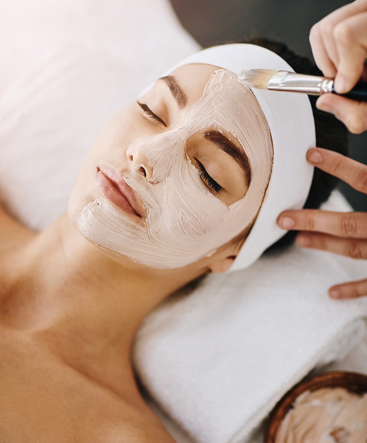 Woman getting facial treatment with soothing mask.