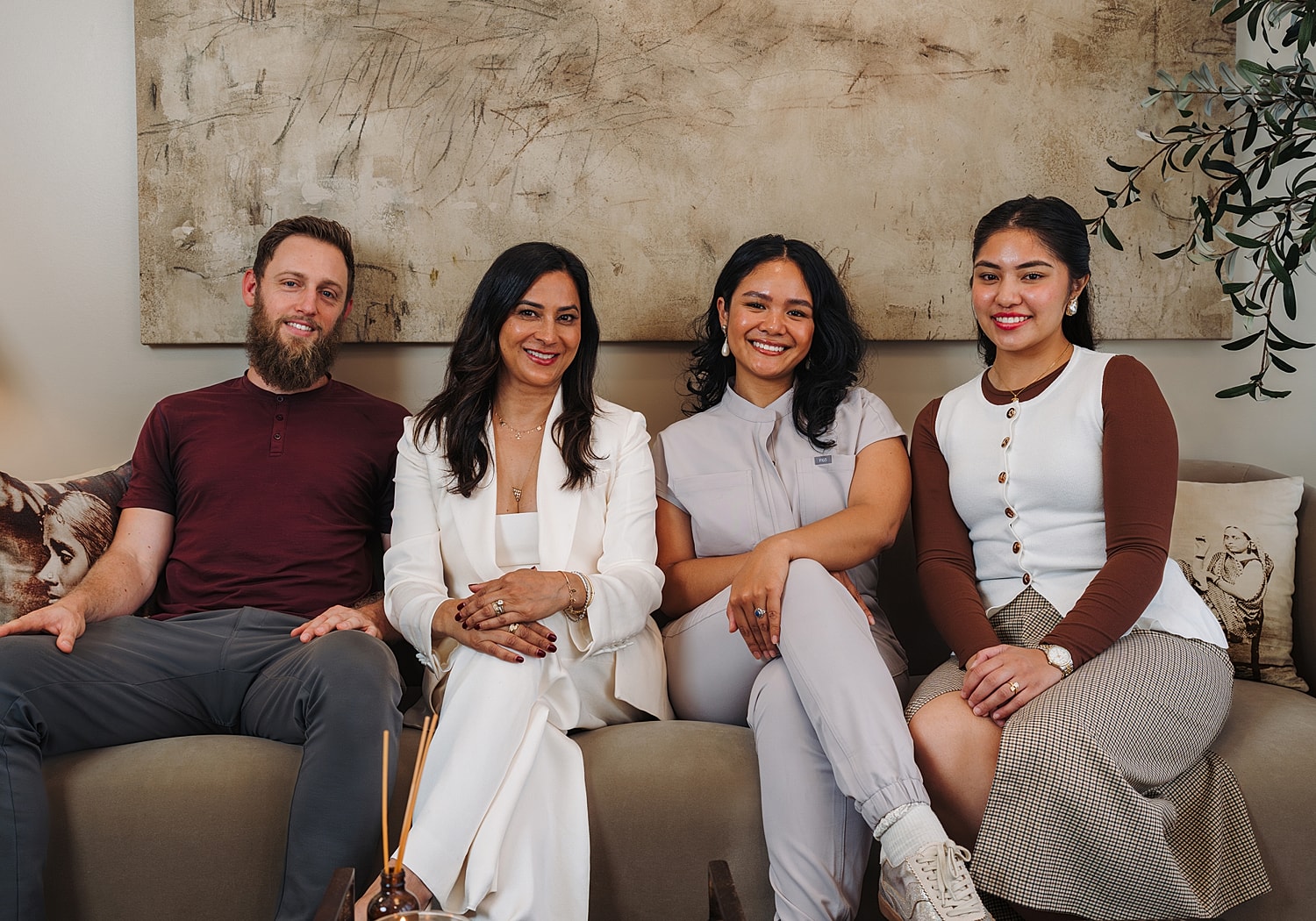 Four people smiling together in a cozy setting.