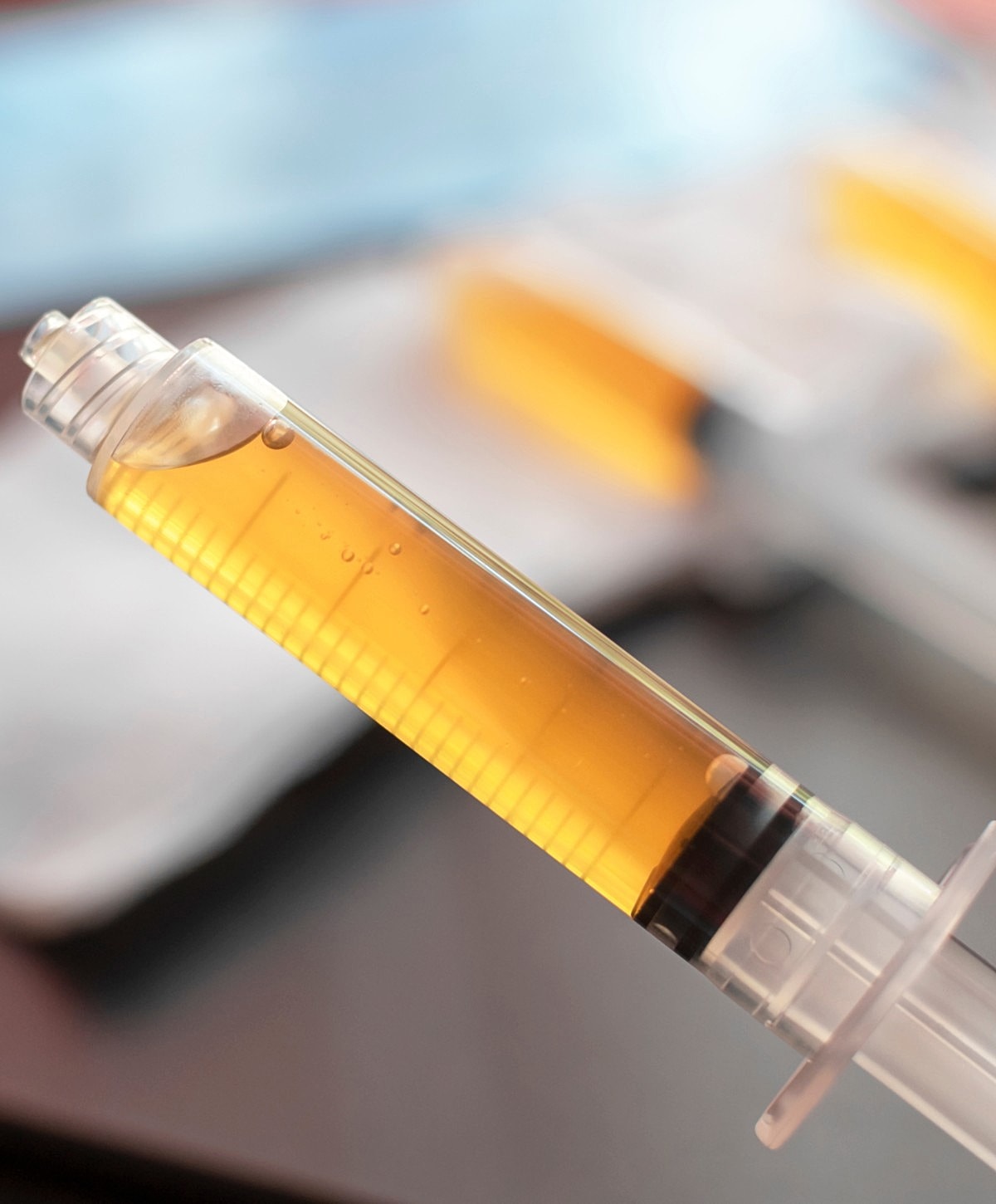 Syringe filled with yellow liquid.