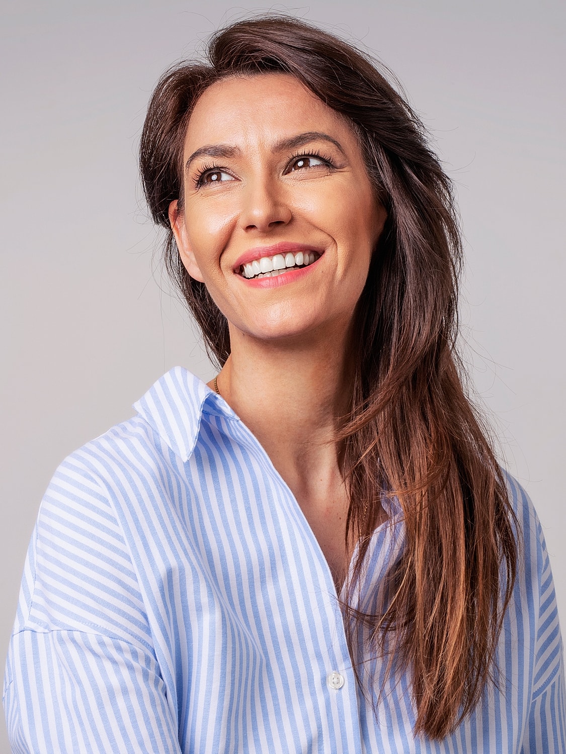 Smiling woman wearing a striped blue shirt