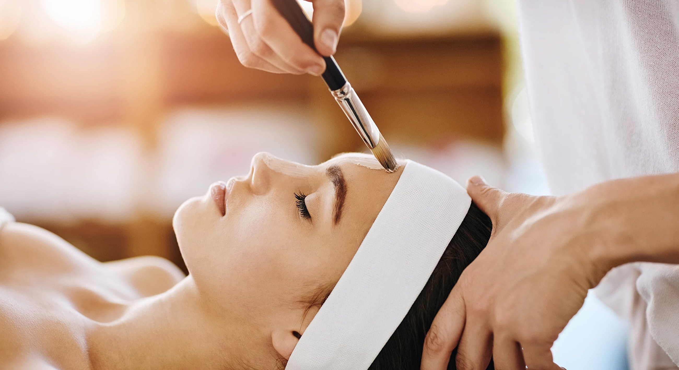 Applying facial treatment in a spa setting.