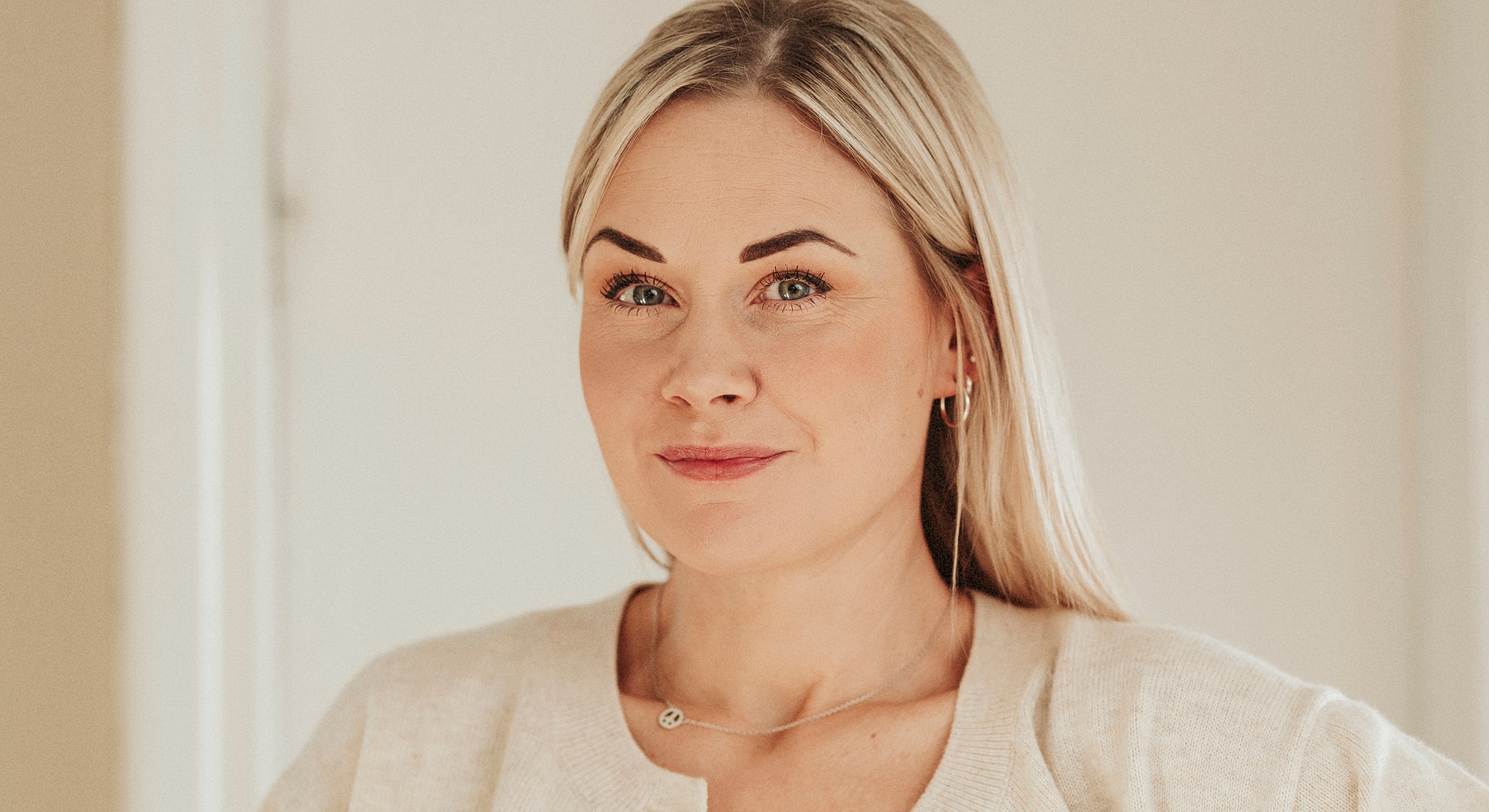 Woman with light blonde hair and soft smile.