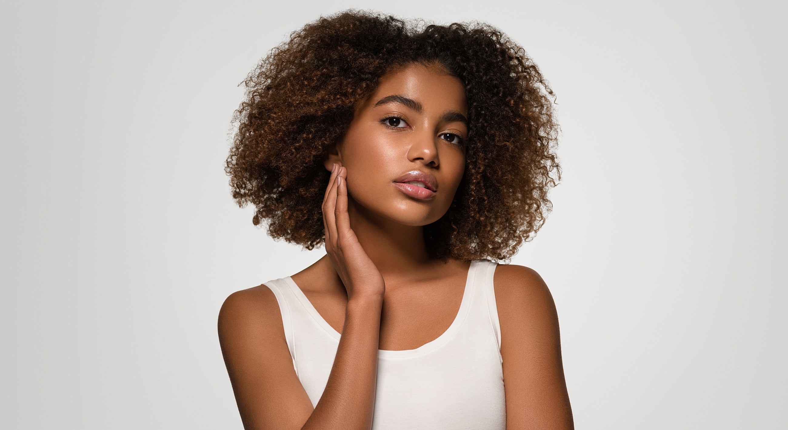 Young woman with curly hair posing thoughtfully